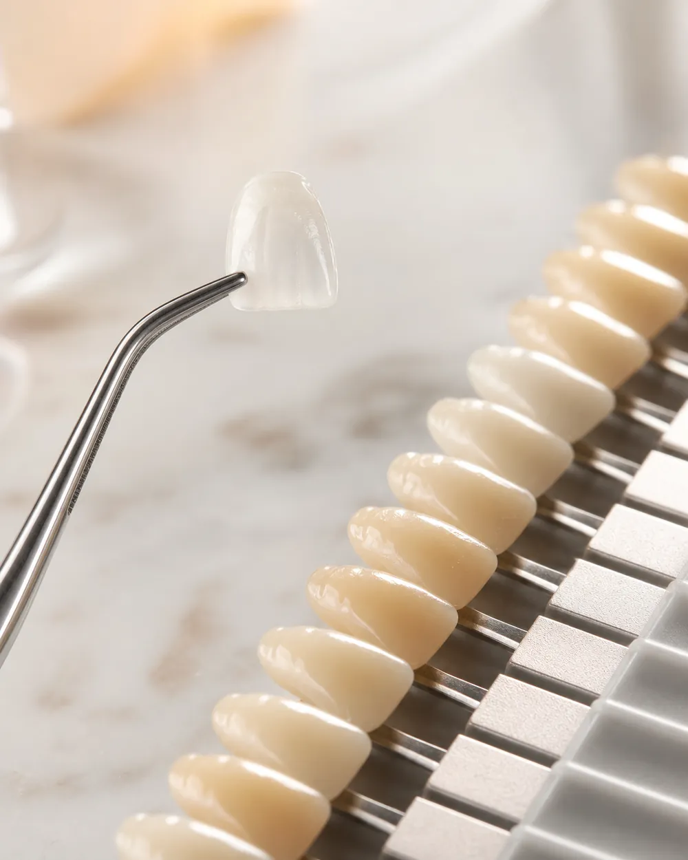 A porcelain veneer held beside a dental shade guide for color matching